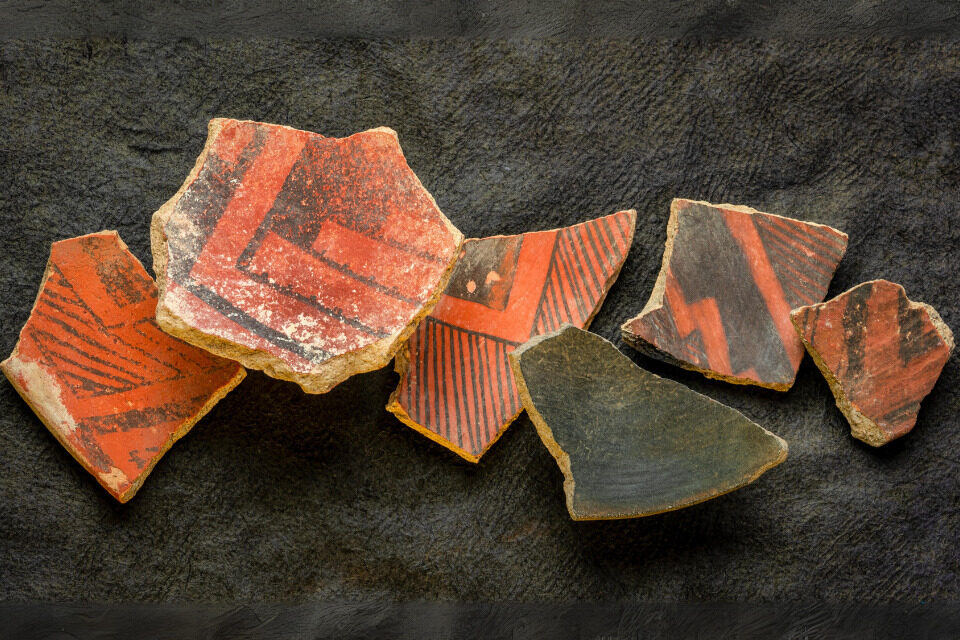 Orange and black pieces of broken pottery